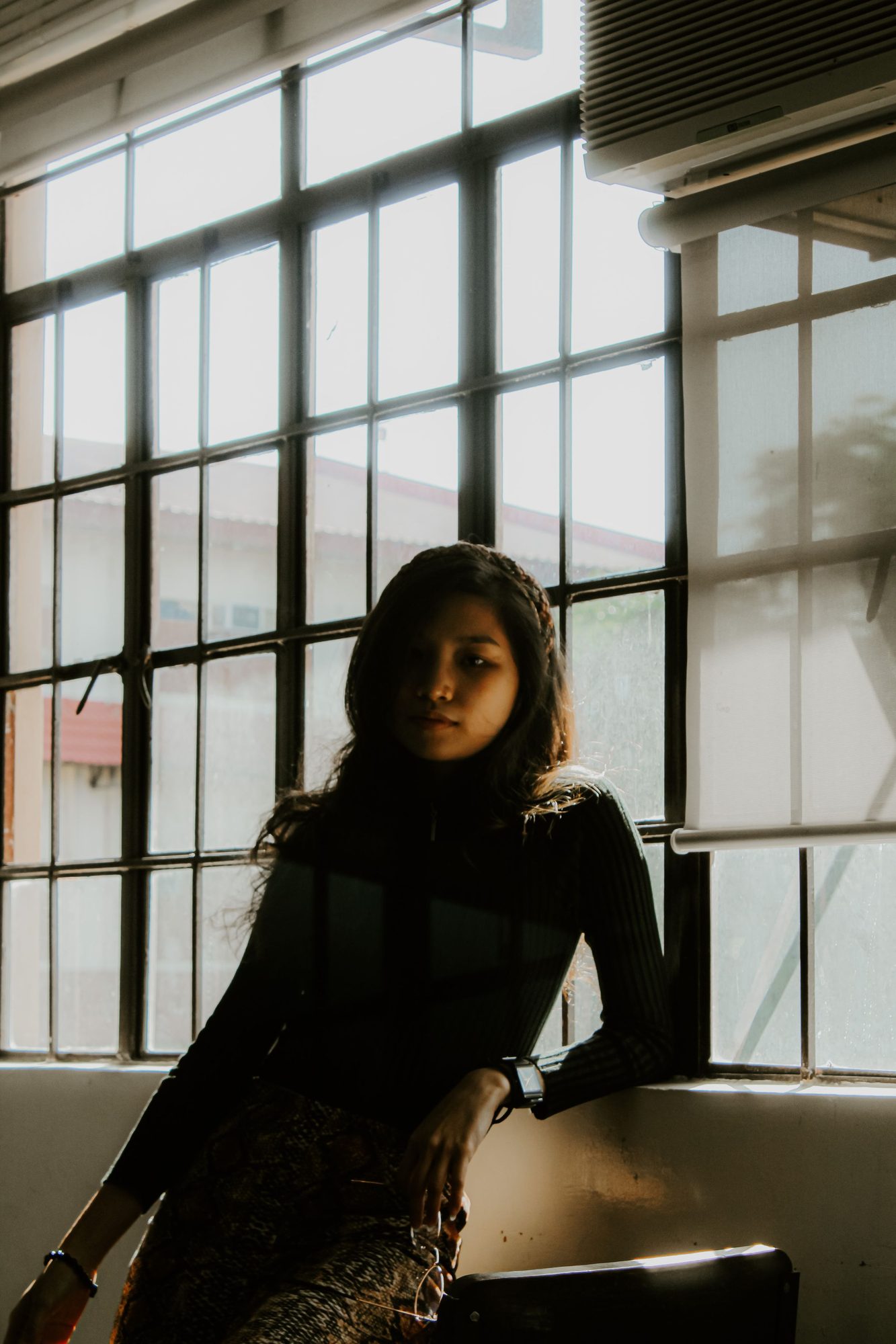 Portrait of the photographer by a tall window
