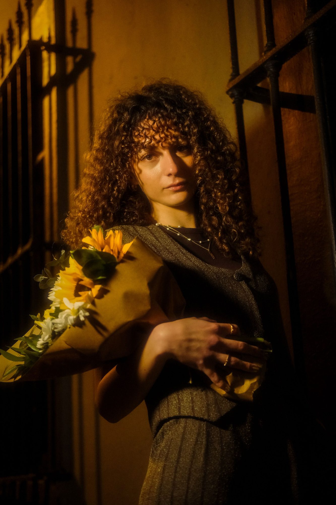 Woman holding sunflowers under warm night light