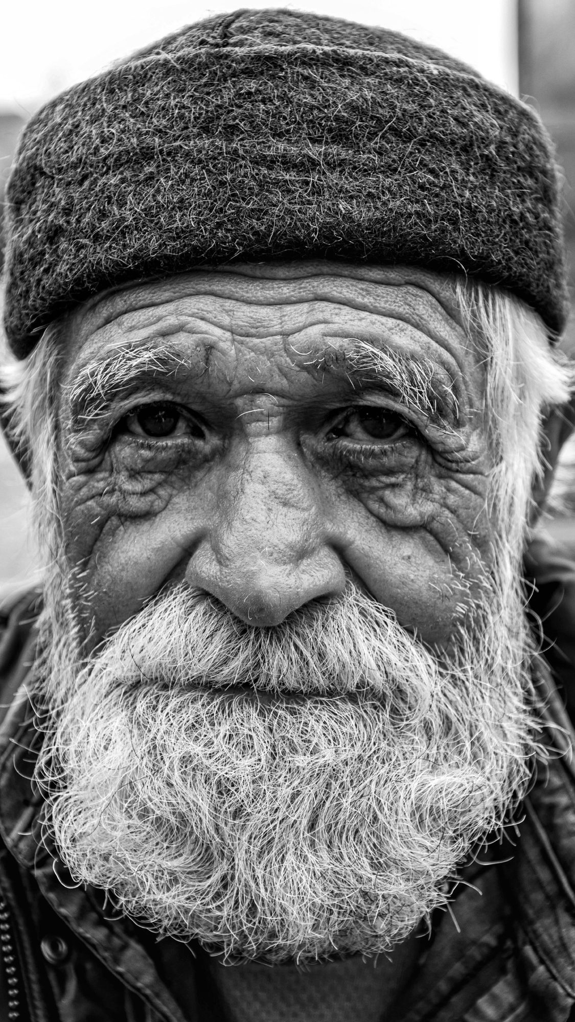 Black and white portrait of an older man in a knit cap